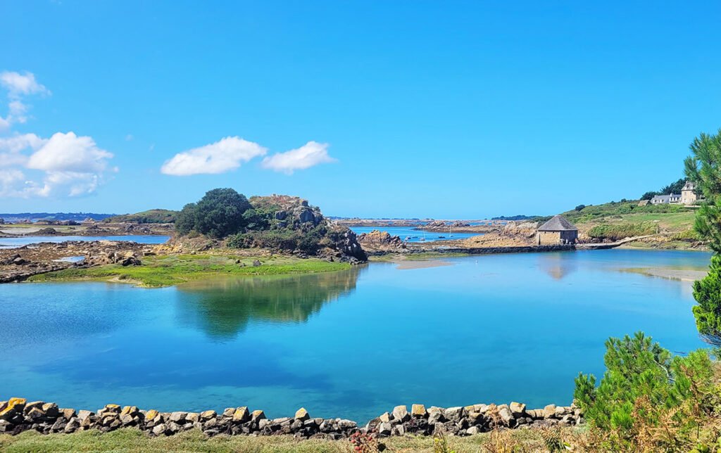 Le moulin du Birlot vue depuis l'île de Bréhat. Couleurs vives et une eau turquoise par une journée ensoleillée.