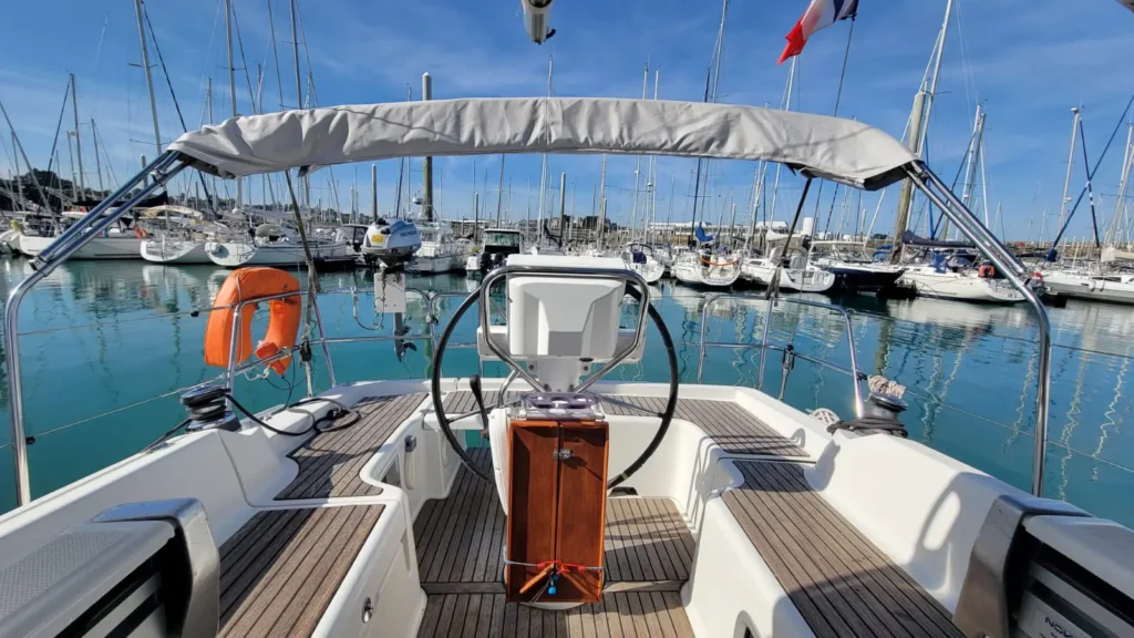 Extérieur d'un voilier de location avec un Bimini ou taud de soleil en Bretagne nord. Pont en teck.