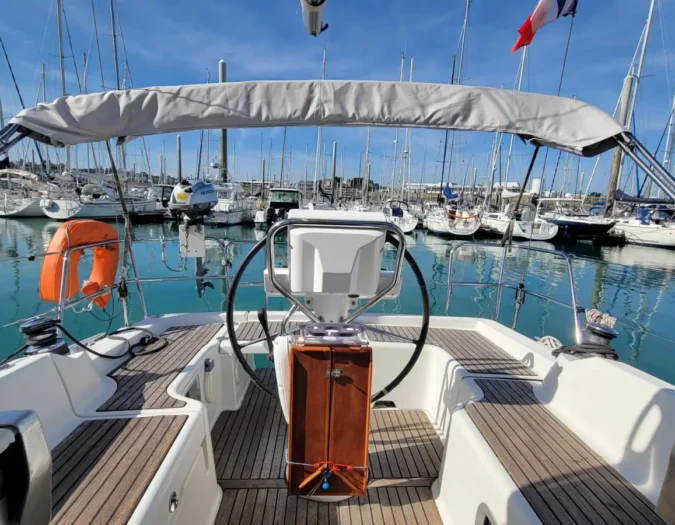 Extérieur d'un voilier de location avec un Bimini ou taud de soleil en Bretagne nord. Pont en teck.