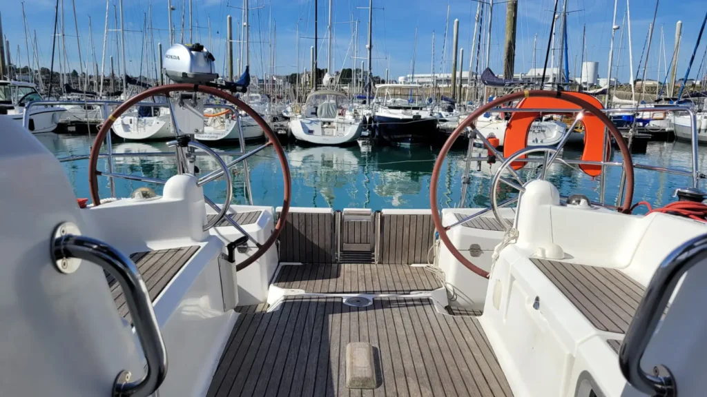 Bateaux dans un port ensoleillé. vue sur le cockpit et sa double barre à roue.