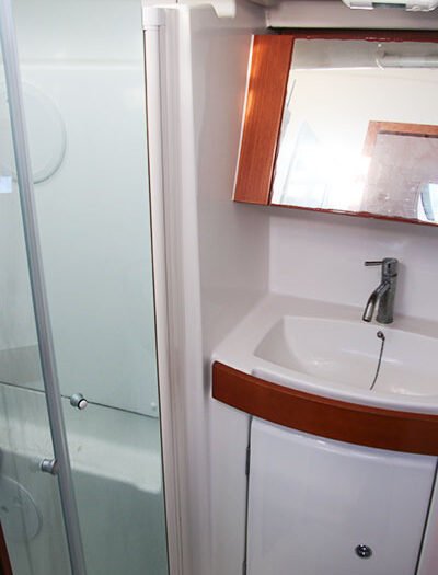 Salle de bain, lavabo et toilettes à l'intérieur d'un voilier Oceanis 40 de location.