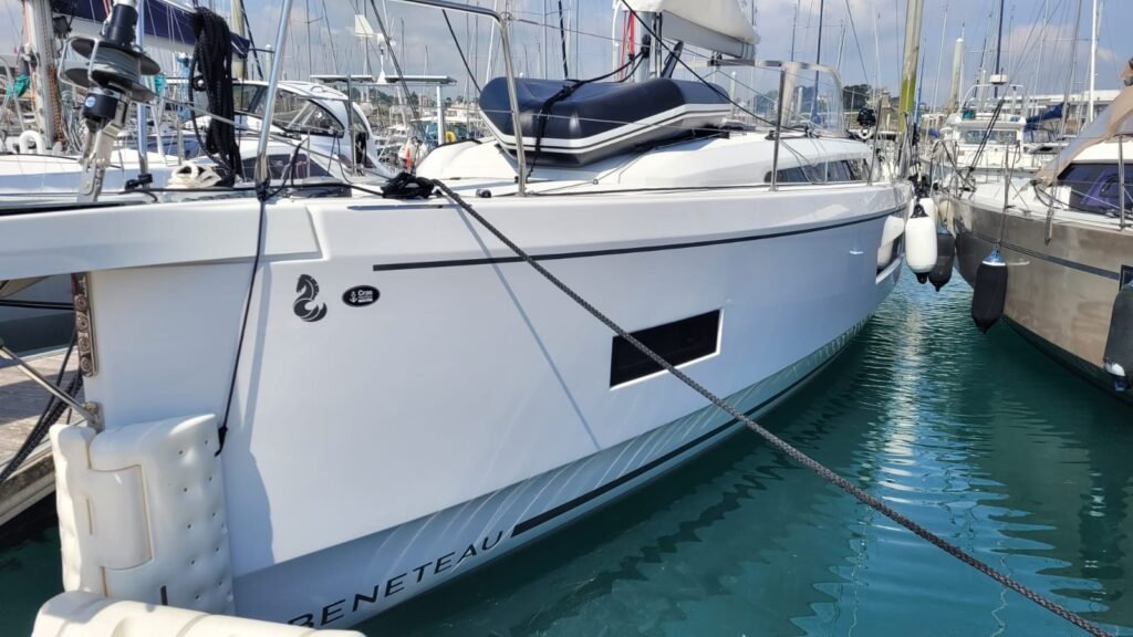 Voilier de type Oceanis 40.1 amarré au port avec son annexe gonflée sur le pont.