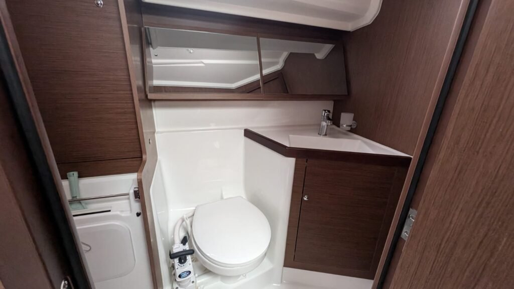 Salle de bain équipage avec lavabo, toilette et douche spacieuse.