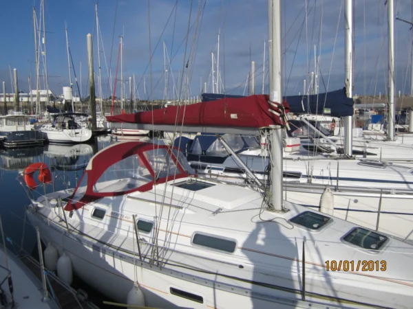 pont d'un bateau à voile, voilier blanc avec un taux et un bimini rouge de type Oceanis 311 en version dériveur lesté.