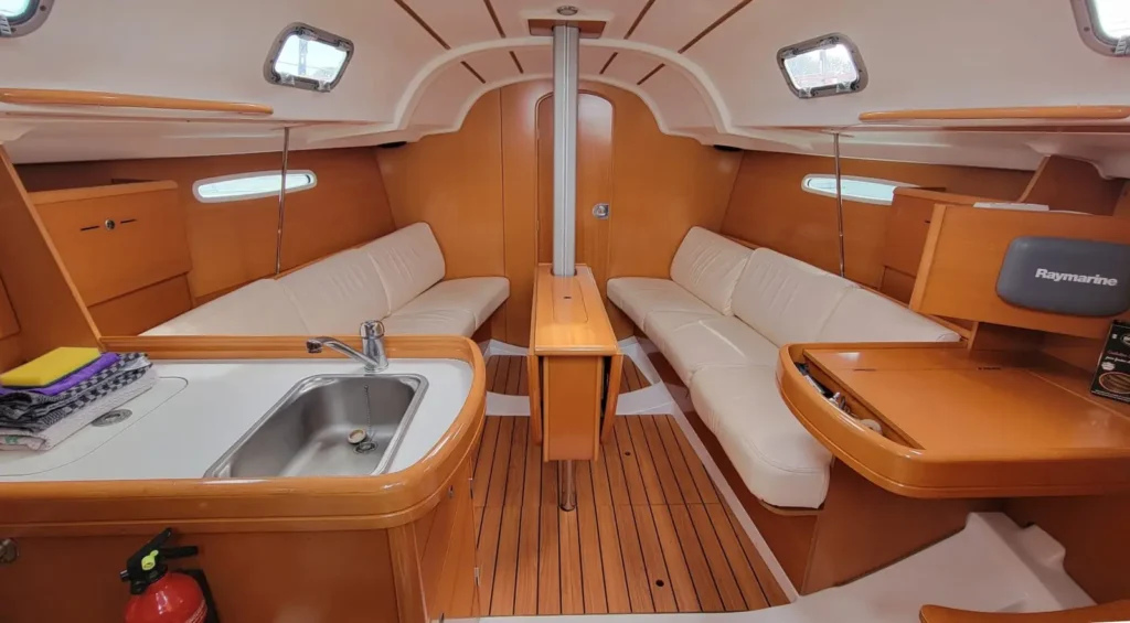 Intérieur boisé du voilier Beneteau First 31.7 en location à Saint-Quay-Portrieux, carré et cuisine