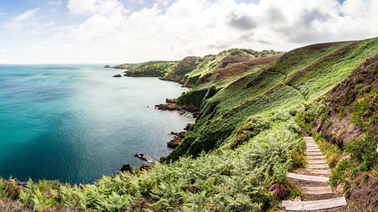 Collines vertes se jetant dans la mer sur l'île de Jersey.