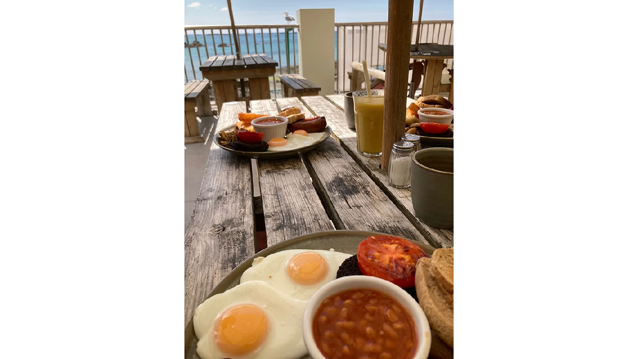 Assiette d'un véritable petit déjeuner anglais avec vue sur la mer à Jersey.