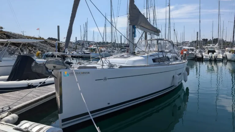 Un voilier DUFOUR 375 avec une coque blanche amarré à son port d'attache.