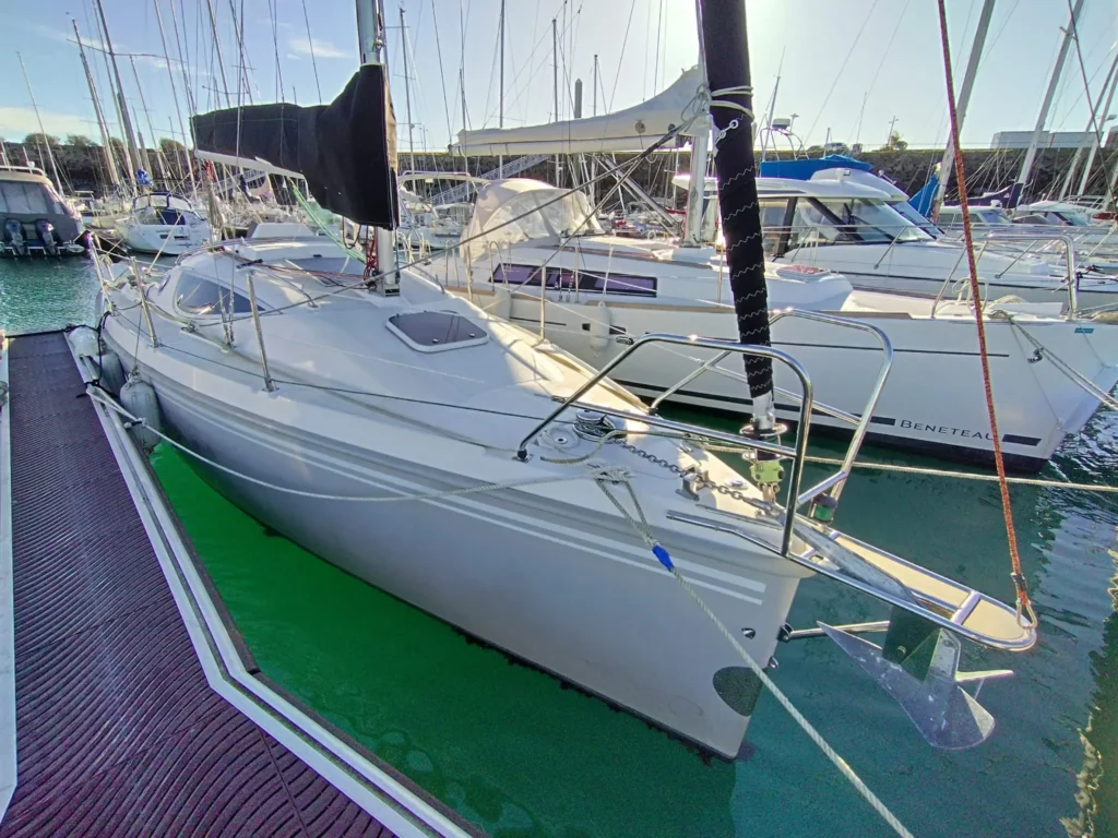 Maxus 28 amarré le long d’un ponton en Bretagne Nord, vue arrière trois-quarts montrant le cockpit, le mât, le gréement et les filières.