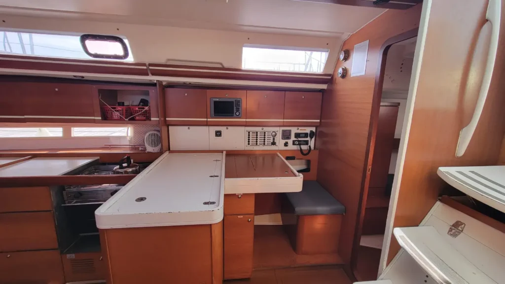 Table à cartes avec traceur, VHF et tableau électrique d'un voilier de location sans skipper en Bretagne Nord