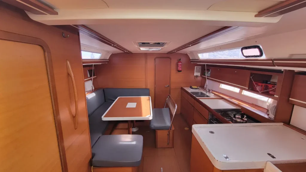 Carré avec grande table et banquette en U du Dufour 445 Grand Large, voilier de location en Bretagne