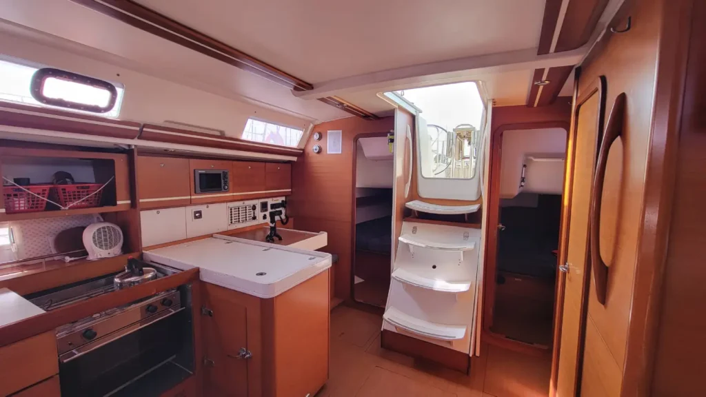 Intérieur d'un voilier 4 cabines avec cuisine en L et accès aux deux cabines doubles arrière