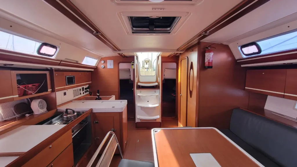 Espace de vie lumineux avec carré, cuisine et descente, à bord d'un voilier de location pour 10 personnes