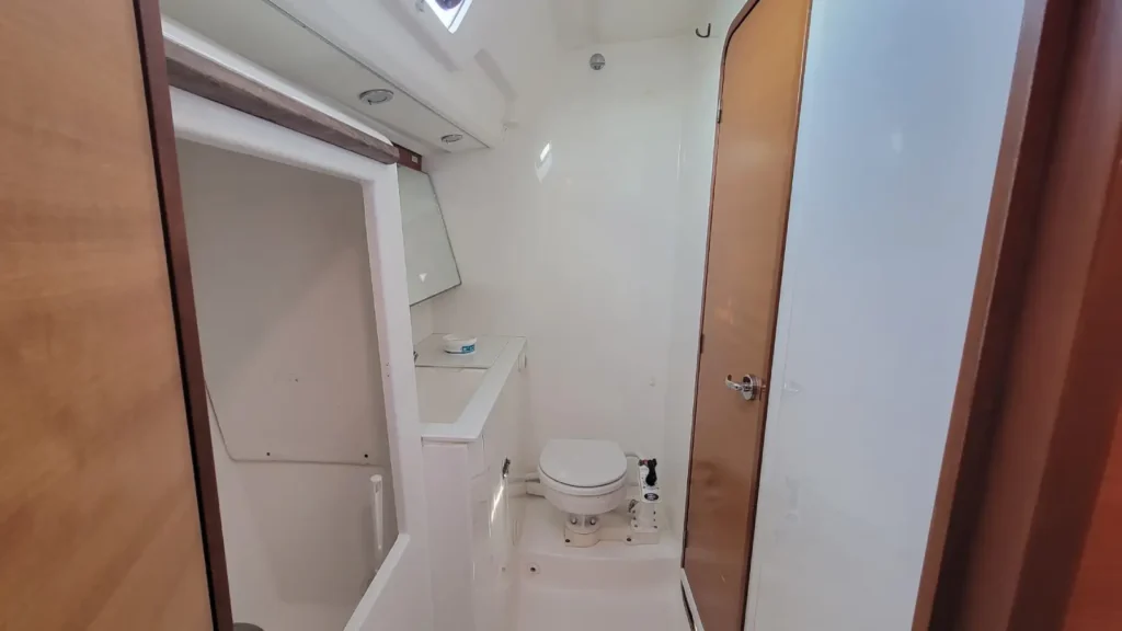 Seconde salle d'eau avec lavabo, miroir et hublot d'un voilier de location 10 couchettes