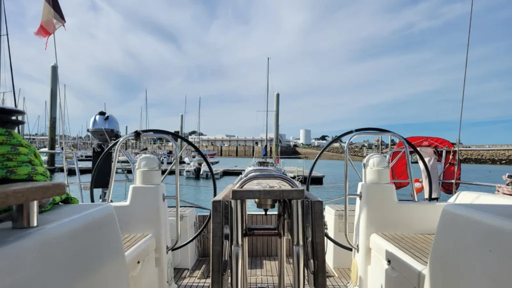 Cockpit et doubles barres à roue d'un voilier 10 places au port en eau profonde de Saint-Quay-Portrieux