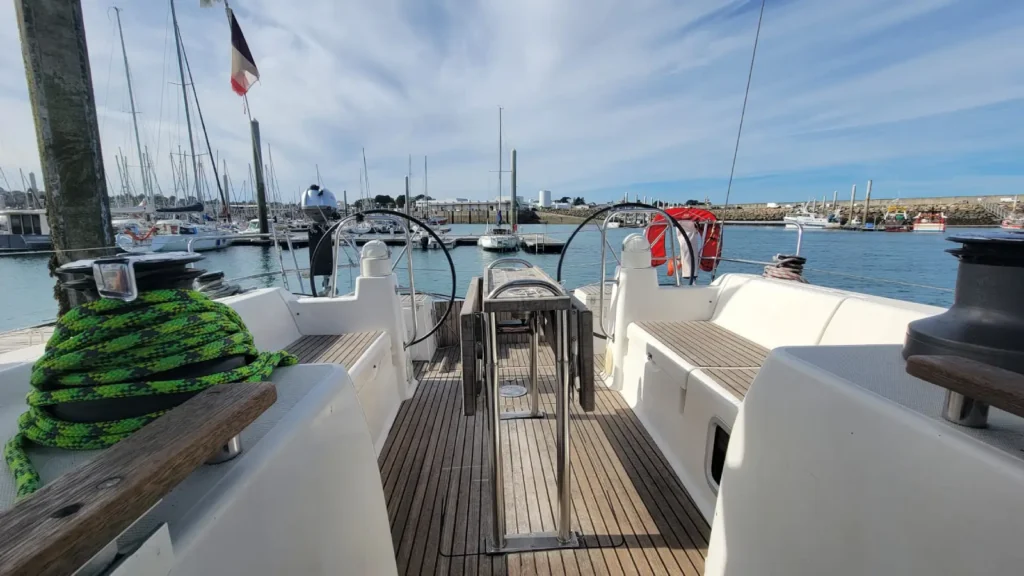 Cockpit en teck avec bancs, winchs et doubles barres d'un voilier de location grande capacité en Bretagne Nord
